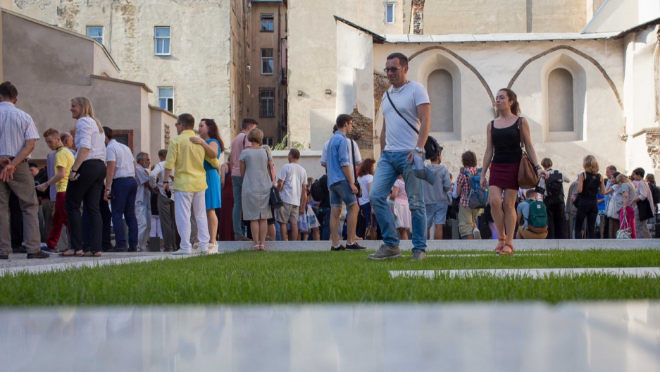 Visitors pass through an open space of grass and polished stone on the former site of the Beth Hamidrash, the study hall adjacent to the Golden Rose synagogue, in Lviv, Ukraine. Visitors pass through an open space of grass and polished stone on the former site of the Beth Hamidrash, the study hall adjacent to the Golden Rose synagogue, in Lviv, Ukraine.